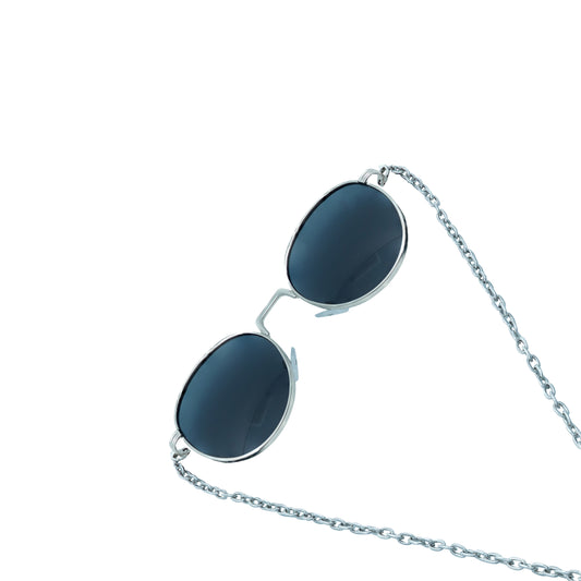 A pair of round, dark-lensed sunglasses with a silver frame is connected to a silver chain, which holds a pendant shaped like a crystal or bullet, featuring a rainbow metallic finish-frame view