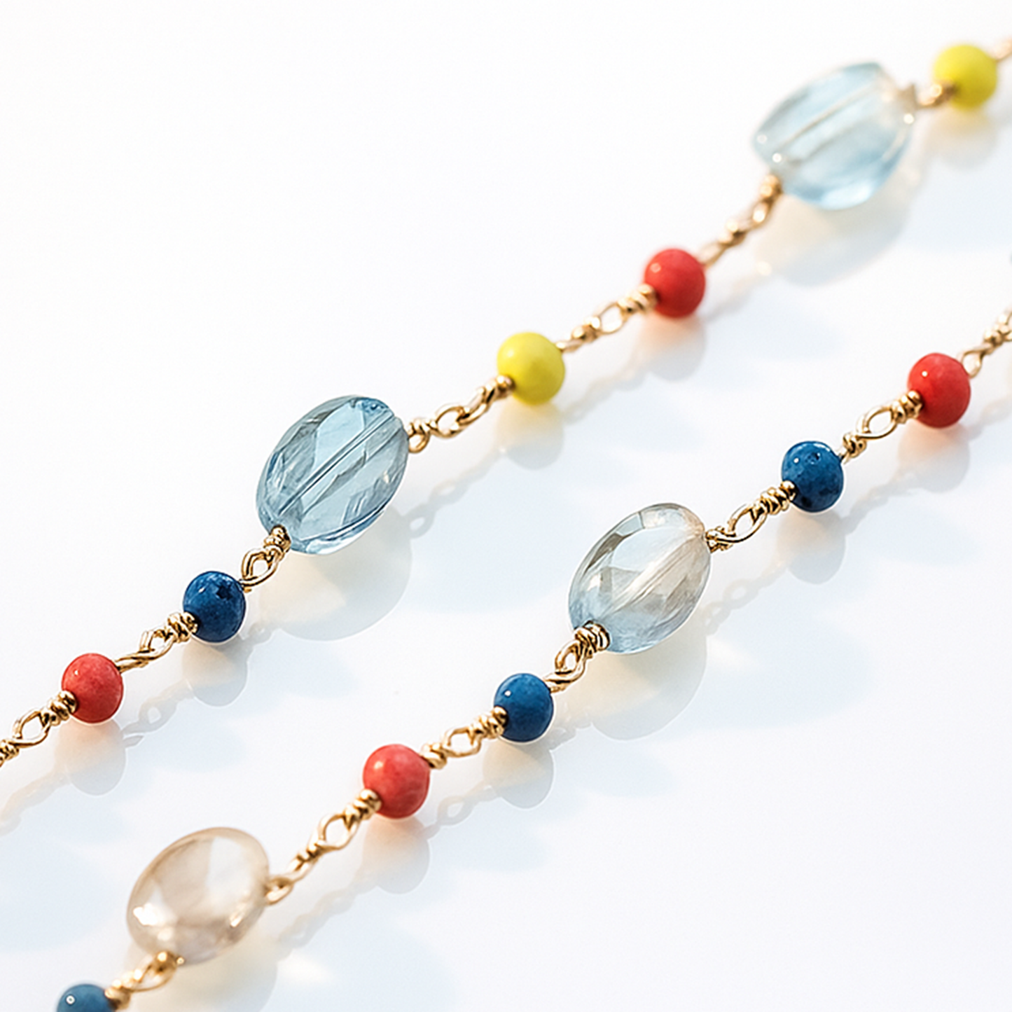 Gold chain with purple gemstone beads in a disc shape linked to colorful beads-zoomed view