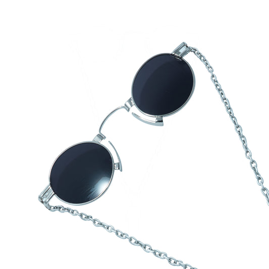 Round oval shaped sunglasses with a silver metallic frame attached to black chain, which holds a pendant shaped black crystal-frame view