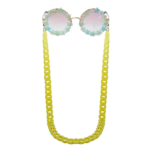 Sunglasses with gradient flower crystal-studded lenses attached to a bold chunky yellow chain-front view