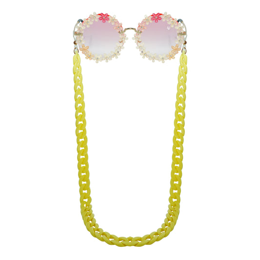 Sunglasses with gradient orange shade flower crystal-studded lenses attached to a bold chunky yellow chain-front view