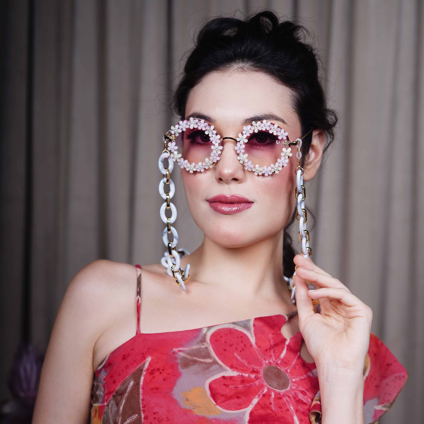 Elegant round sunglasses with floral crystal-studded finishing, adorned with a white funky chain for a playful vibe-angle view