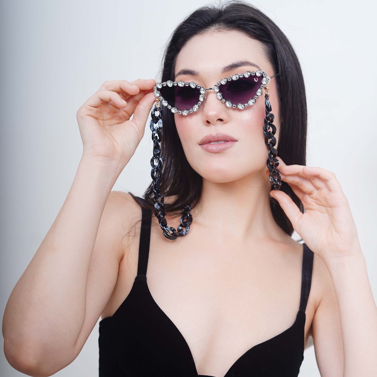 Glimmery oval crystal-studded cat-eye frames with purple gradient lenses attached with a blue-black gradient chain for fashion lovers-side pose