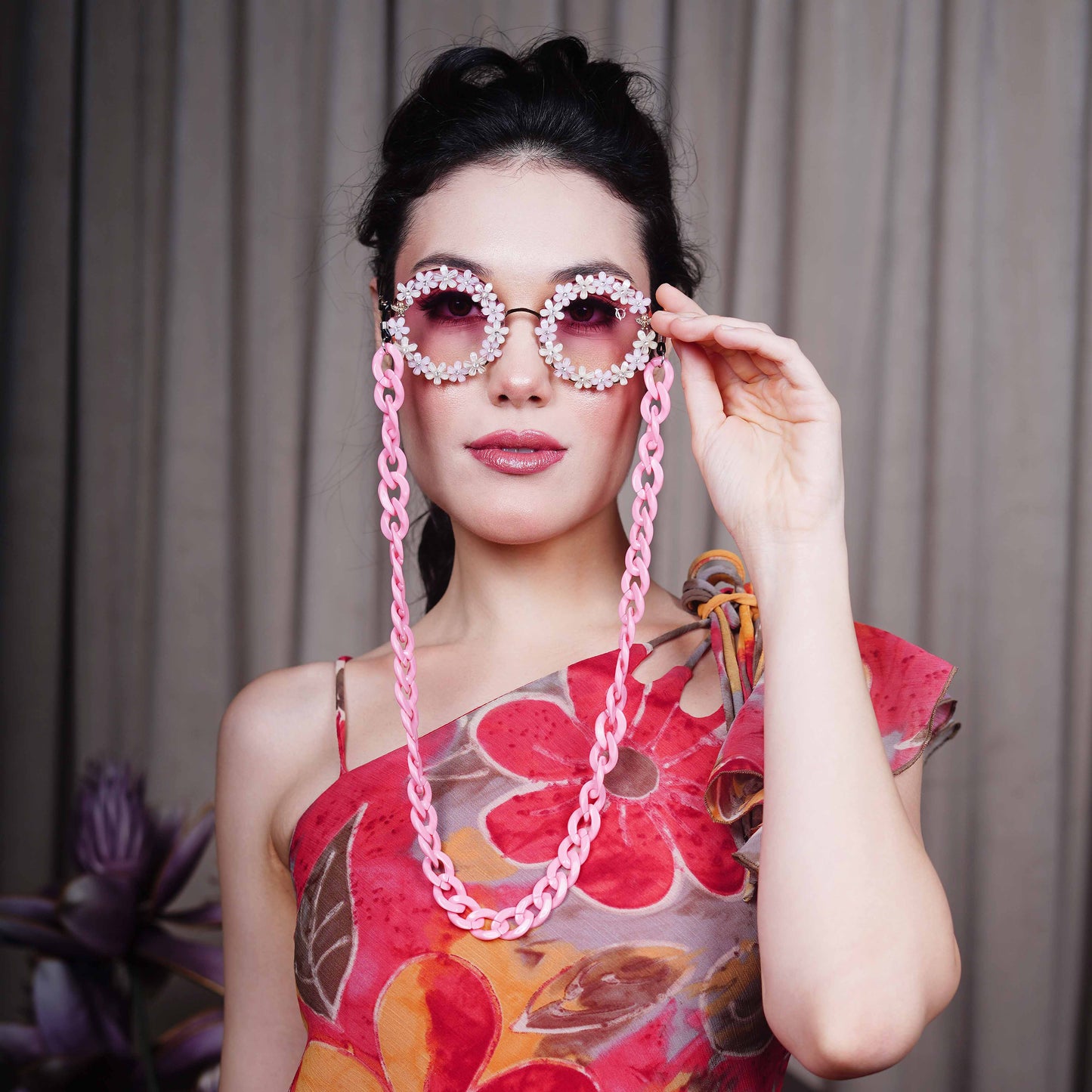 Elegant round sunglasses with floral crystal-studded finishing, adorned with a pink funky chain for a playful vibe-straight pose