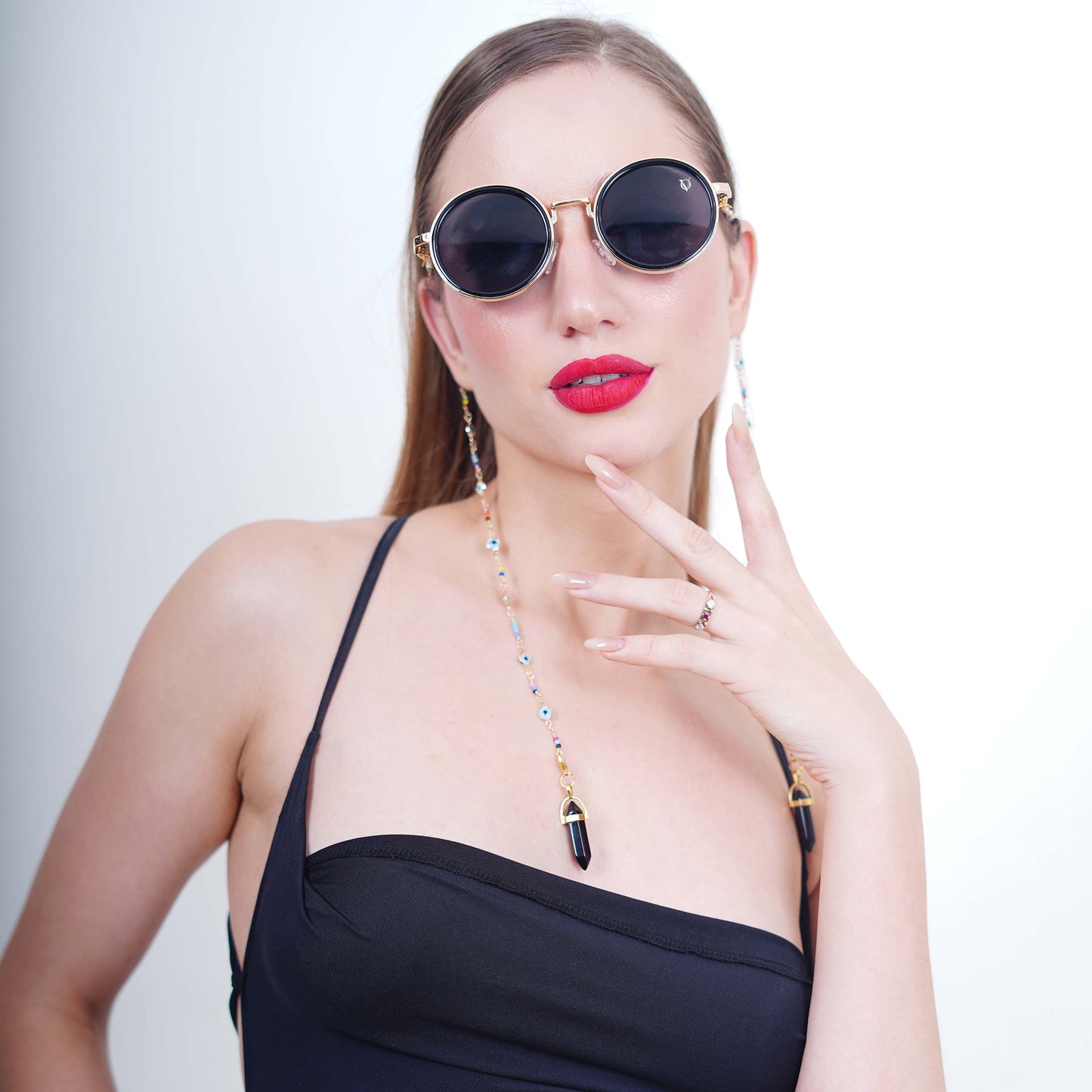 Large round sunglasses with dark shade golden finishing lenses adorned with evil-eye multi-colored gold chain and black charms with gold metal holder-front pose
