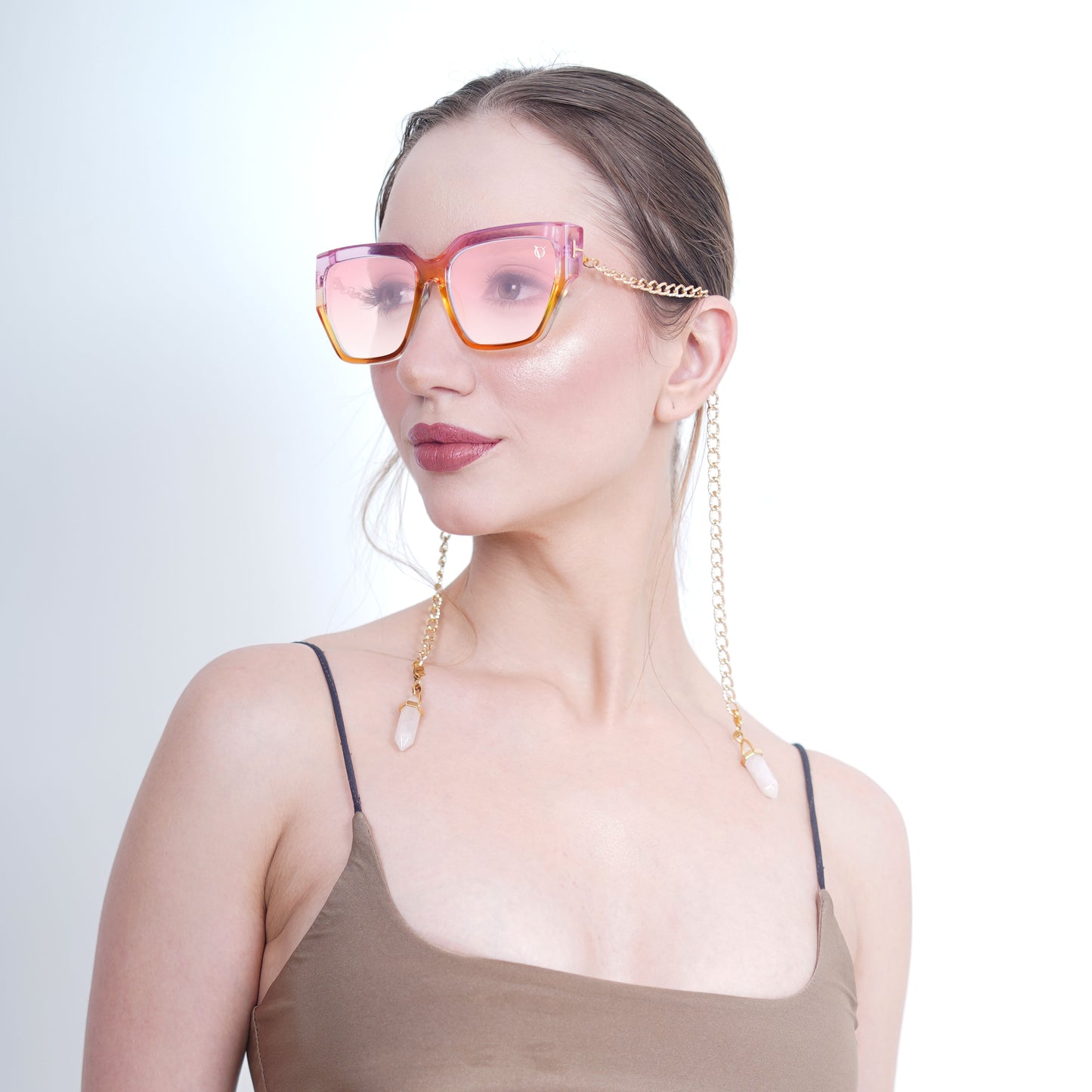 Trendy oversized orange-pink gradient large orange colored sunglasses with a golden chain and translucent white charms-side view