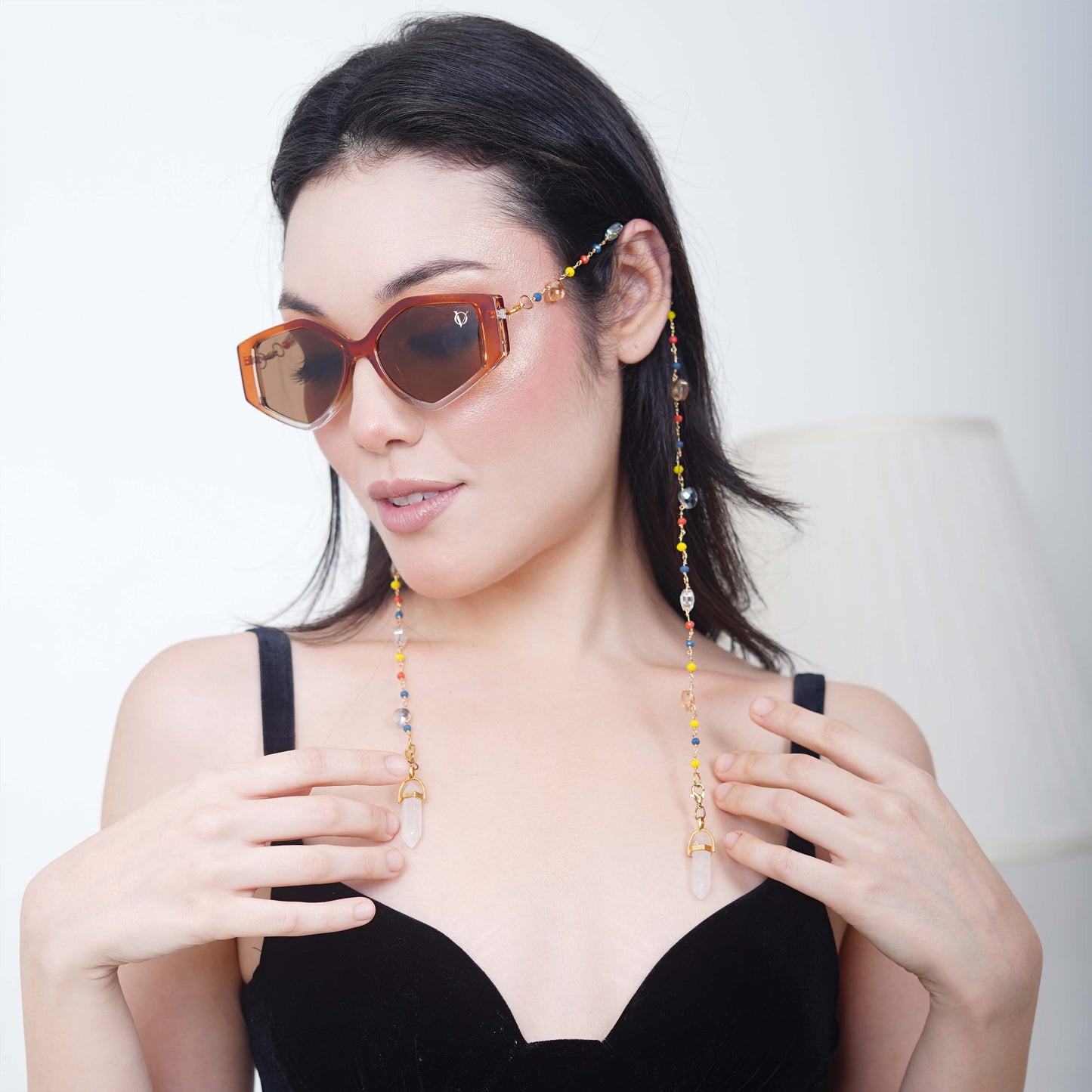 Bold oversized hexagonal frames with multicolored small beads balanced with light translucent crystal and white charms for women's fashion-styling pose
