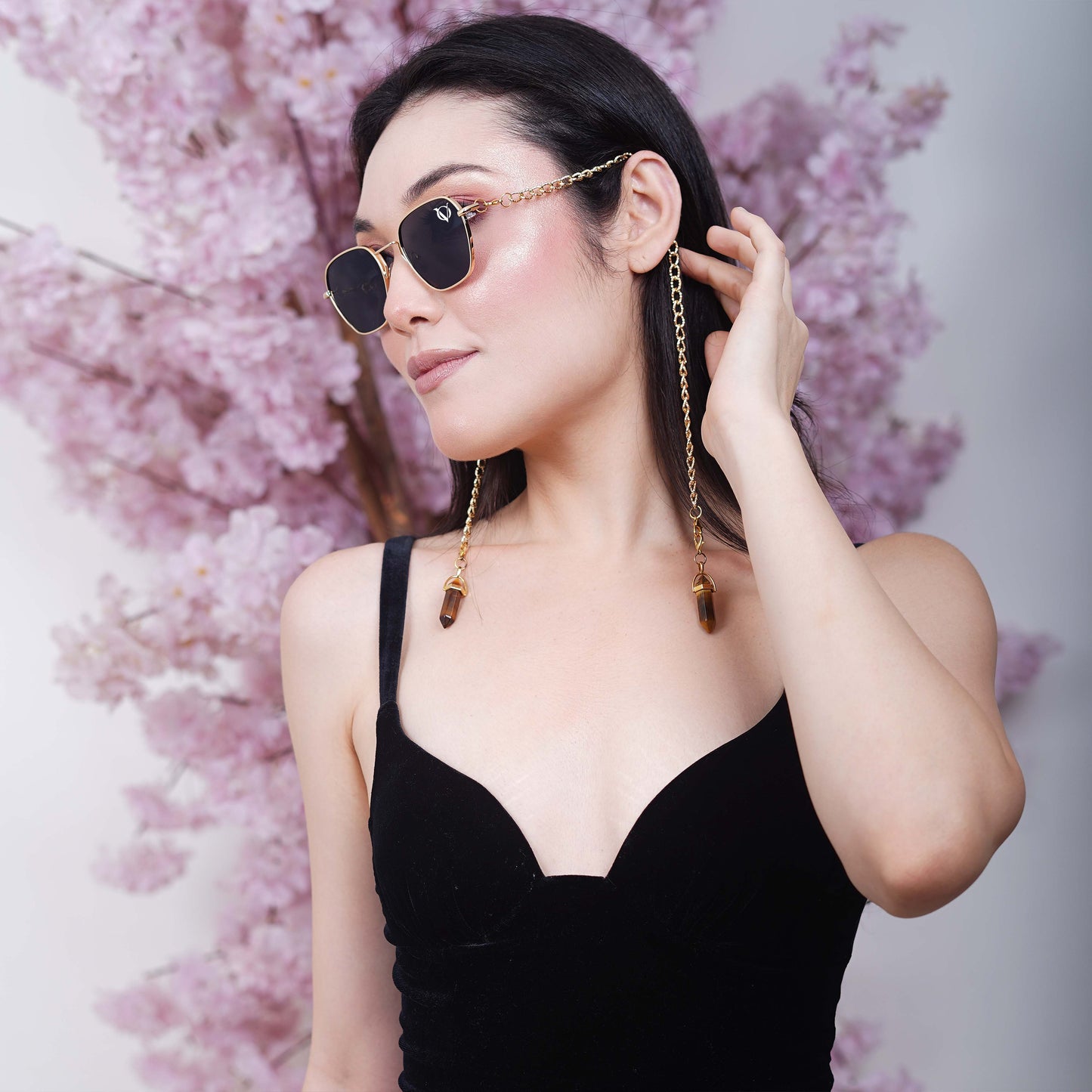 Black tinted large lenses with gold finishing attached with a golden chain with golden clear lenses finished with a gold metal holder-side pose