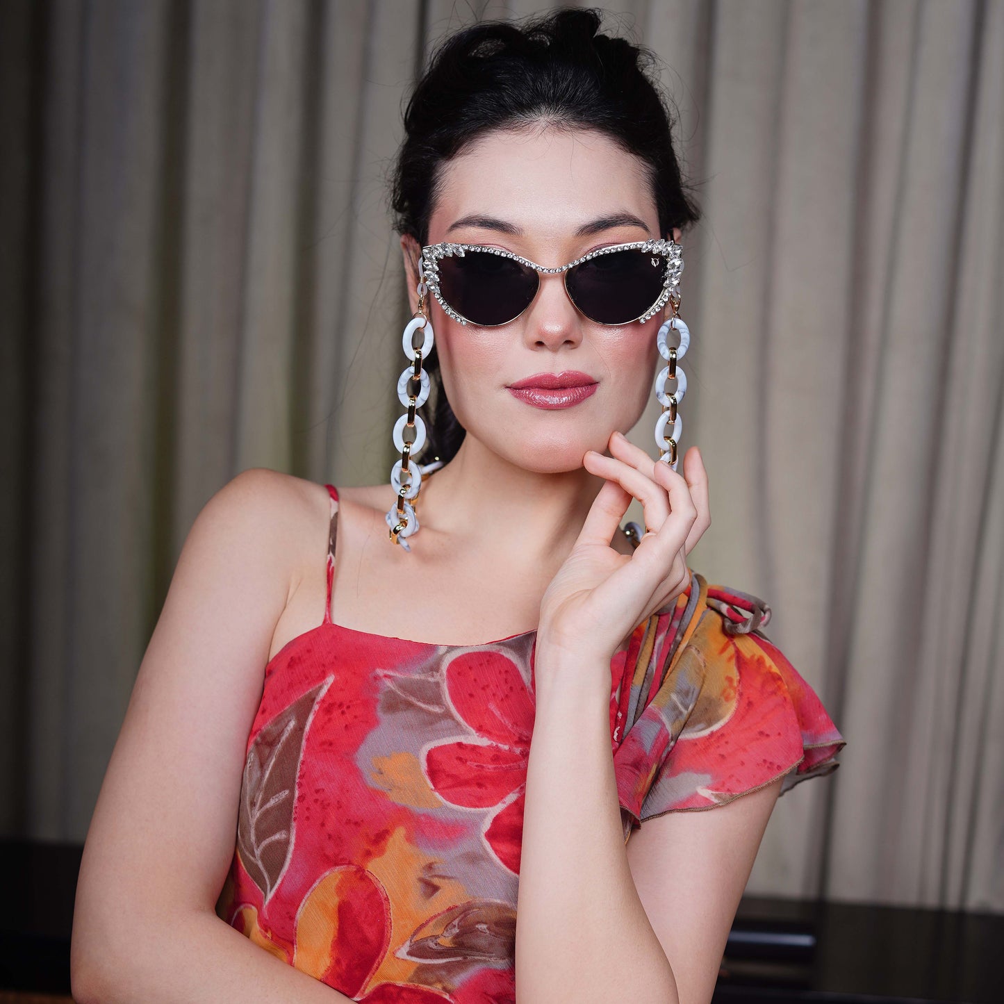 Best crystal-studded cat-eye frames sunglasses with a white chain linked with a gold linker for women's to go to a party-angle pose