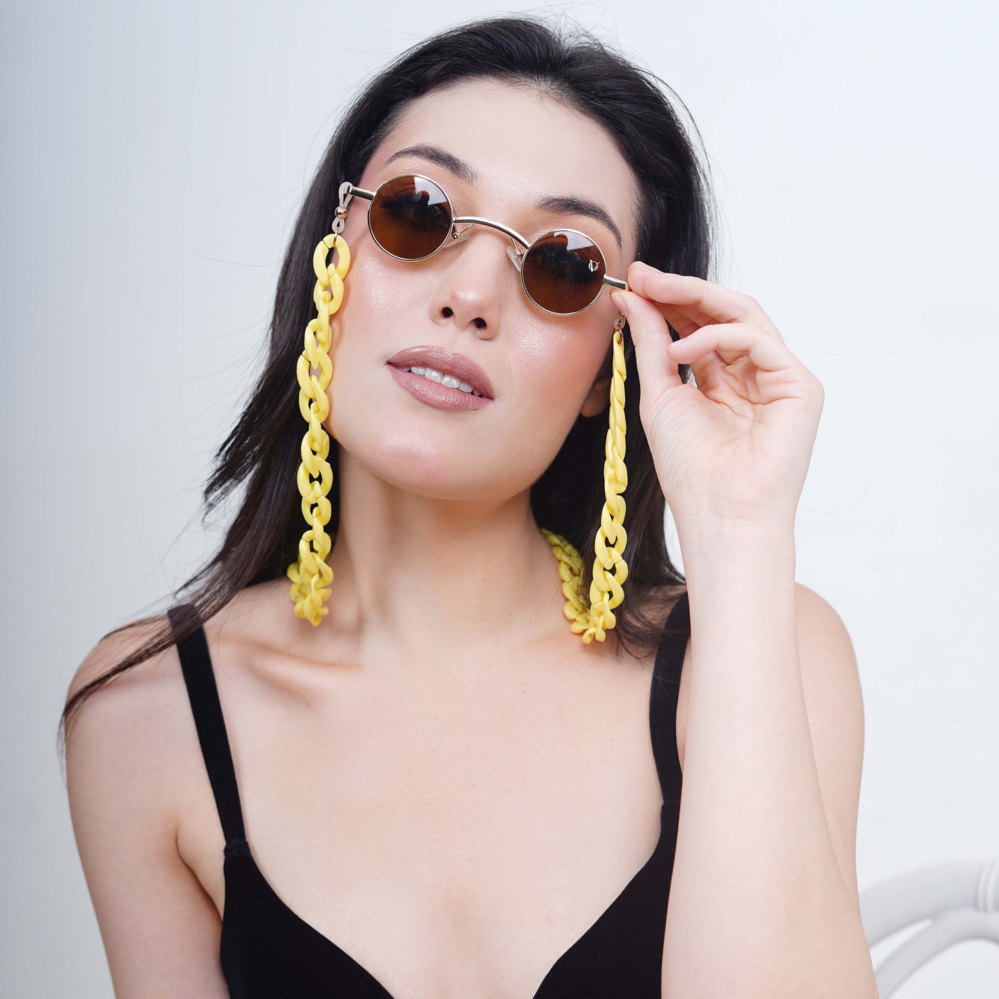 Small-sized sized charming, round, oval brown tinted shades lenses attached with a yellow funky chain-front pose
