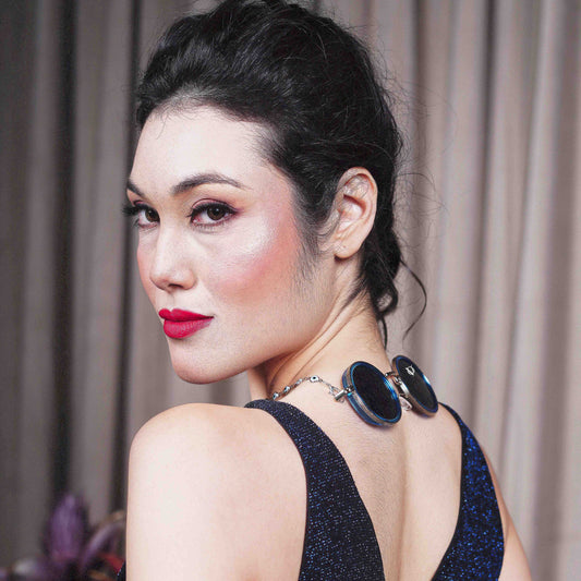 Trendy oversized blue round lenses adorned with a silver-tone evil eye chain and translucent white charm for a fashion statement-back angle pose