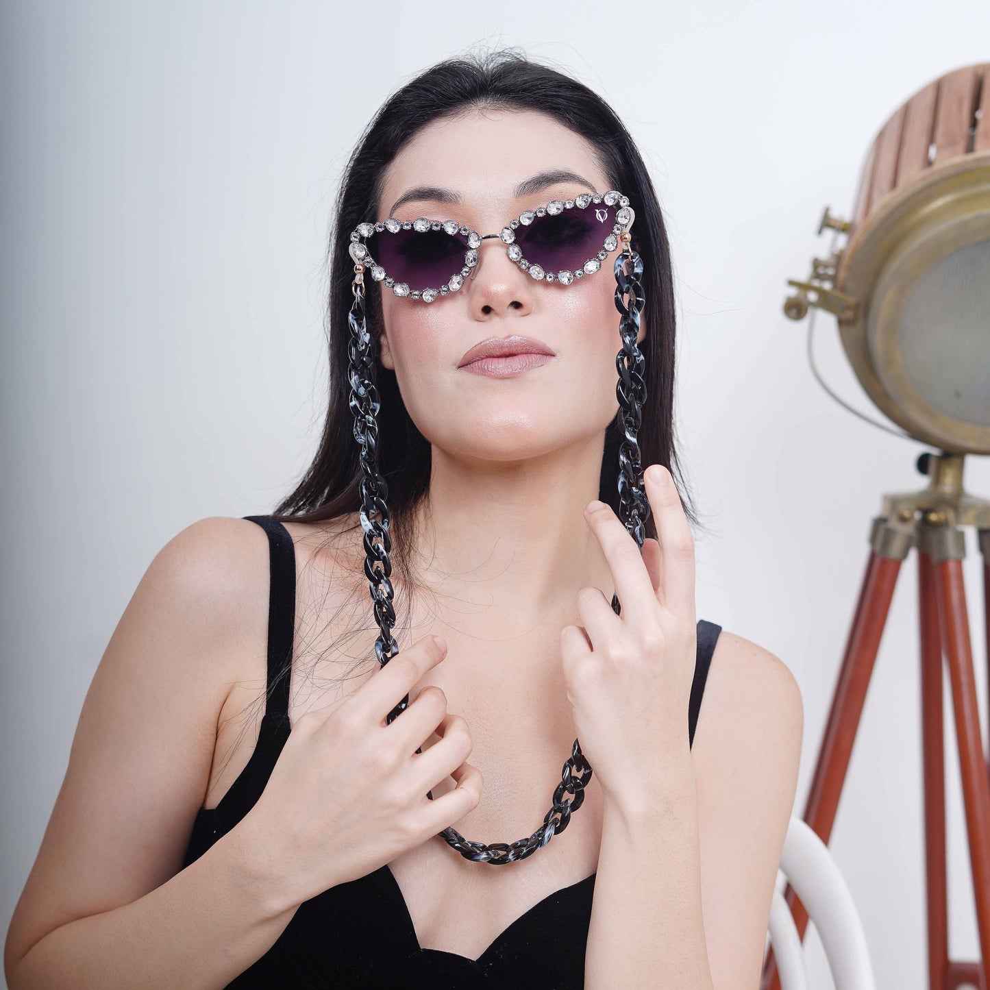 Glimmery oval crystal-studded cat-eye frames with purple gradient lenses attached with a blue-black gradient chain for fashion lovers-front styling view