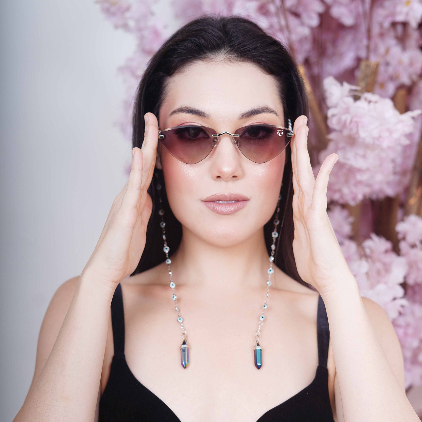 Luxury cat-eye frames with brown-gold tinted lenses adorned with silver-toned evil eye chain and multicolored vibrant charms-front pose