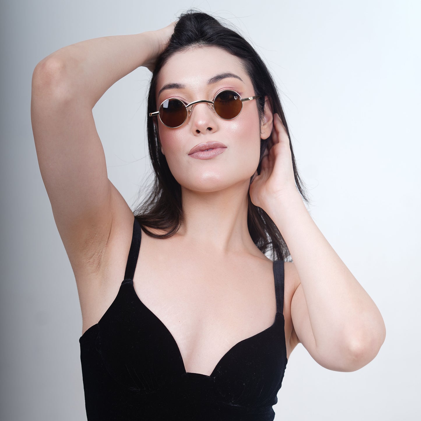 Round sunglasses with golden metallic frame and brown tinted lenses-front view