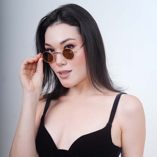 Round sunglasses with golden metallic frame and brown tinted lenses-model view