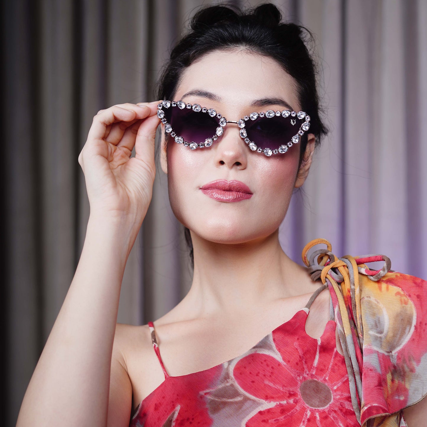 Cat-eye sunglasses with dark purple lenses and a rhinestone-embellished frame-face view