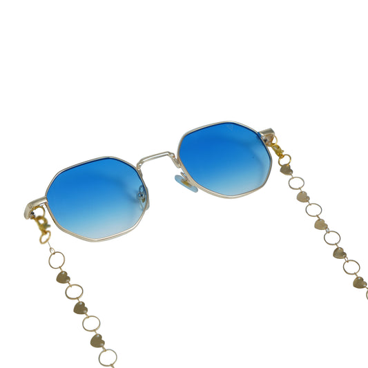 Blue-lensed sunglasses with a gold frame are connected to a delicate gold chain adorned with small circular links