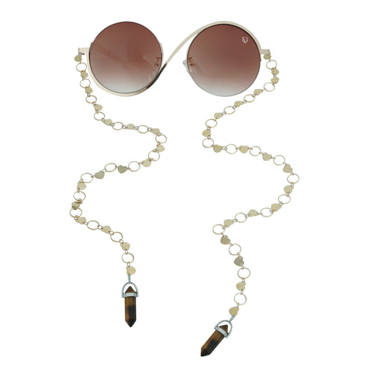 Round sunglasses with dark lenses, a silver frame, and a dual-link gold chain strap, or oval rings and leaf discs featuring tiger-eye charms-front view