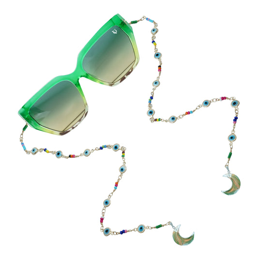 Green sunglasses with gradient lenses attached to a colorful beaded chain featuring evil eye accents and crescent shaped crystal pendants-angle view