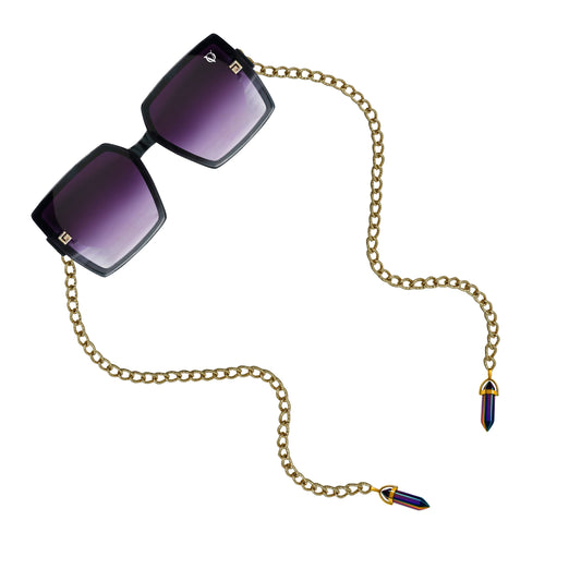 Square sunglasses with dark purple gradient lenses attached to a golden chain featuring gold detailing-angle view