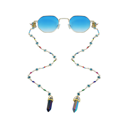 Blue-lensed sunglasses with a silver frame are attached to a beaded chain featuring blue and multicolored accents, ending in two crystal charms-front view