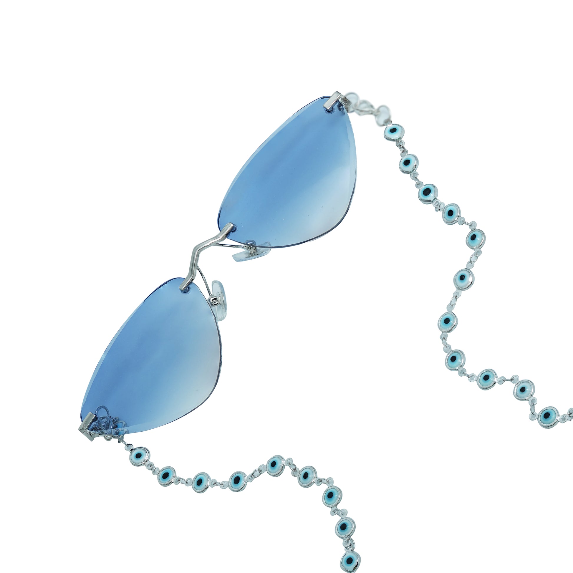 A pair of cat-eye framed sunglasses with a silver frame is connected to a silver evil-eye chain, which holds a pendant shaped blue crystal(Blue Stone)-frame view