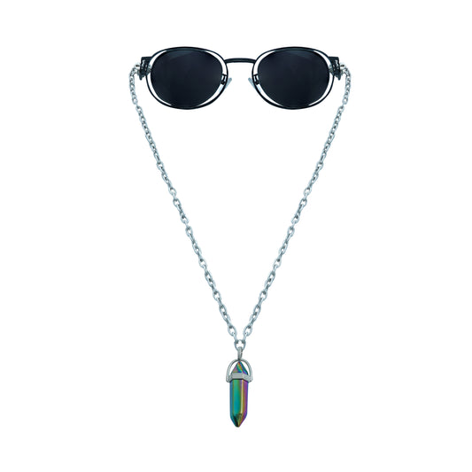 A pair of round, dark-lensed sunglasses with a silver frame is connected to a silver chain, which holds a pendant shaped holographic vibrant rainbow crystal-front view