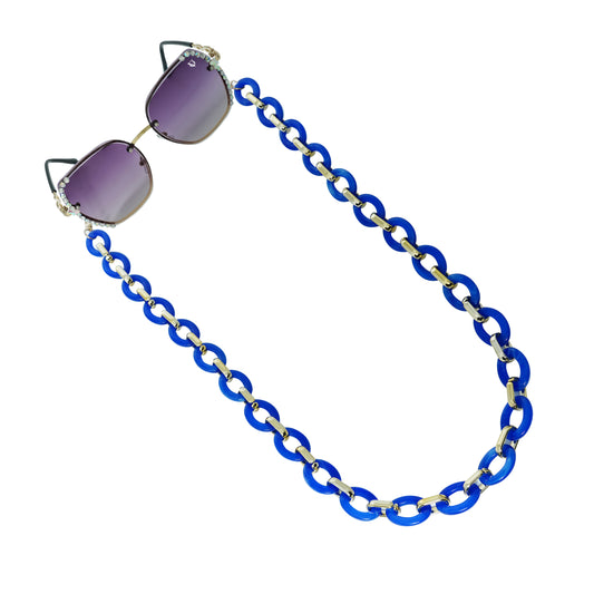 Sunglasses with gradient lenses attached to a bold chunky blue chain -angle view