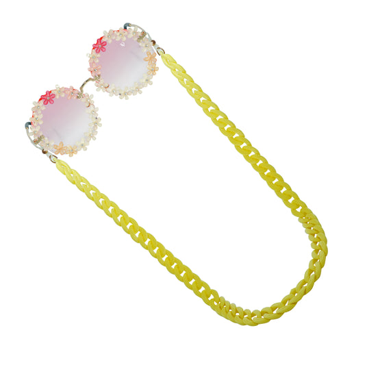 Sunglasses with gradient orange shade flower crystal-studded lenses attached to a bold chunky yellow chain-angle view

