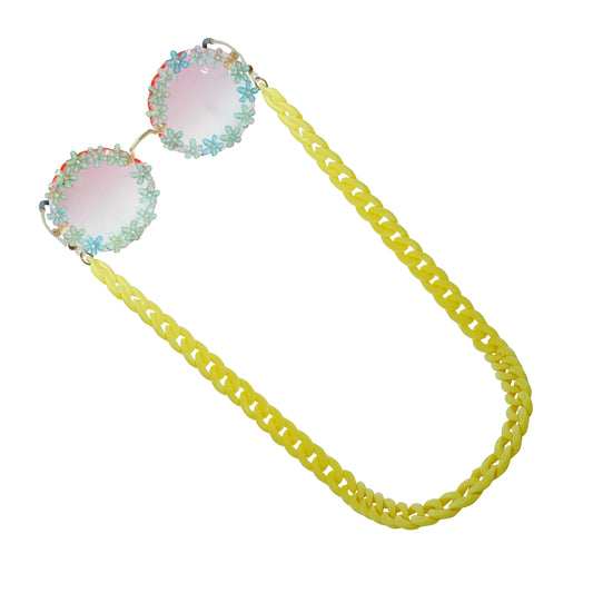 Sunglasses with gradient flower crystal-studded lenses attached to a bold chunky yellow chain-angle view
