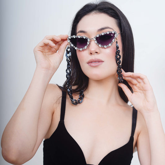 Glimmery oval crystal-studded cat-eye frames with purple gradient lenses attached with a blue-black gradient chain for fashion lovers-side pose