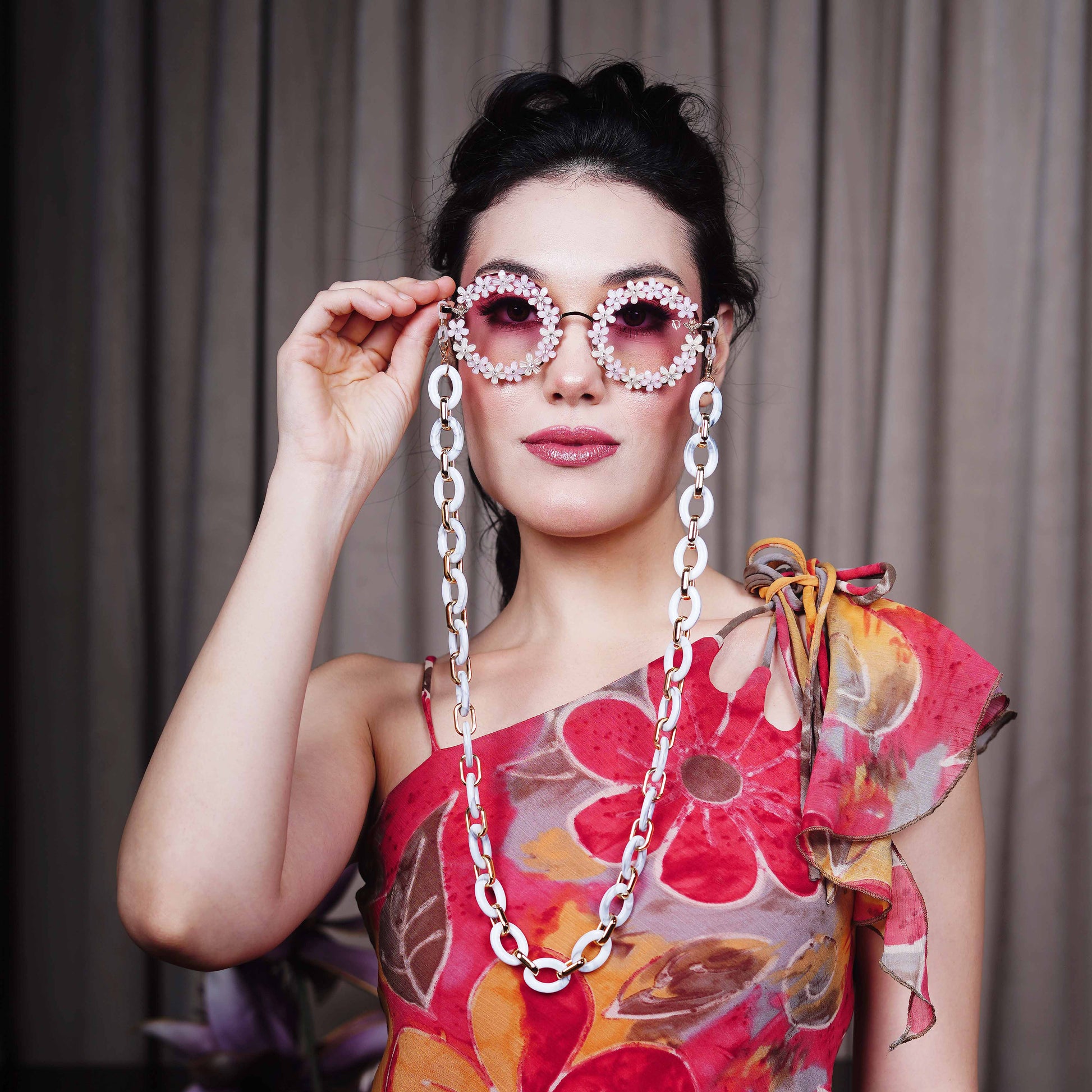 Elegant round sunglasses with floral crystal-studded finishing, adorned with a white funky chain for a playful vibe-front view