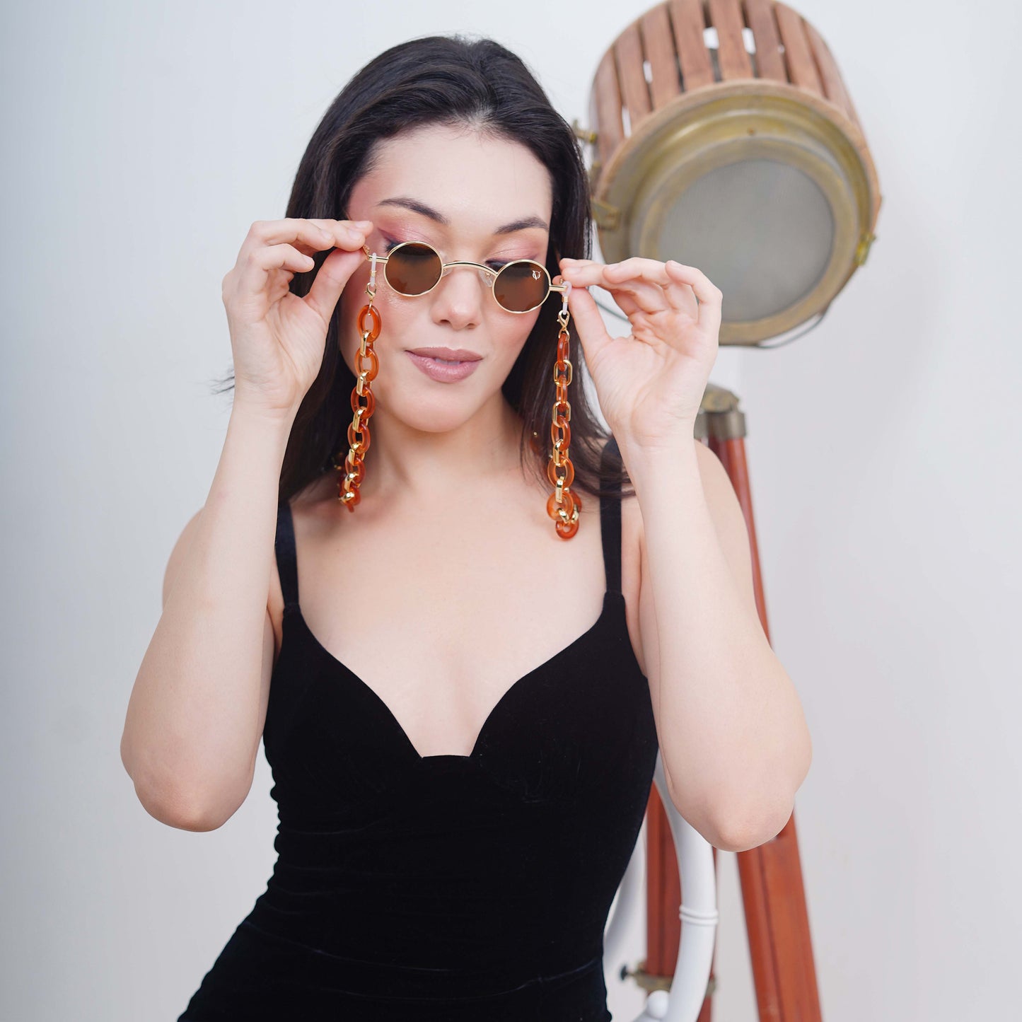 Luxurious brown tinted round oval lenses attached with a large funky orange chain linked with a gold linker.