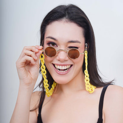 Small-sized sized charming, round, oval brown tinted shades lenses attached with a yellow funky chain-smiling pose