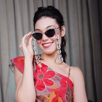 Best crystal-studded cat-eye frames sunglasses with a white chain linked with a gold linker for women's to go to a party-sunglass holding pose 