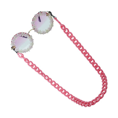 Elegant round sunglasses with floral crystal-studded finishing, adorned with a pink funky chain for a playful vibe-tilted pose