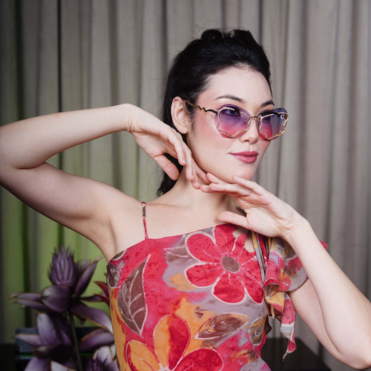 stylish heart-shaped sunglasses with purple-pink gradient lenses and a decorative golden frame-side view