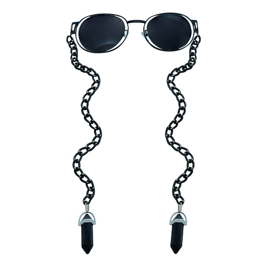 A pair of round, dark-lensed sunglasses with a silver frame is connected to a black chain, which holds a pendant shaped black crystal(Obsidian Stone)-front view
