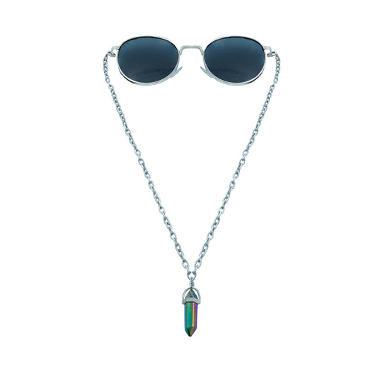 A pair of round, dark-lensed sunglasses with a silver frame is connected to a silver chain, which holds a pendant shaped like a crystal or bullet, featuring a rainbow metallic finish-front view