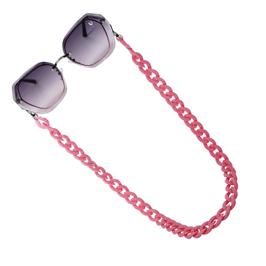 Sunglasses with purple gradient hexagonal frame lenses attached to a bold chunky pink chain-angle view